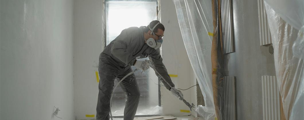 Contractor working on asbestos removal in a commercial building.