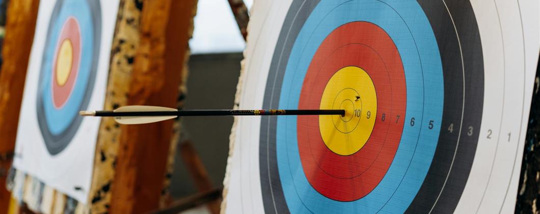 Archery target with an arrow in the bullseye.