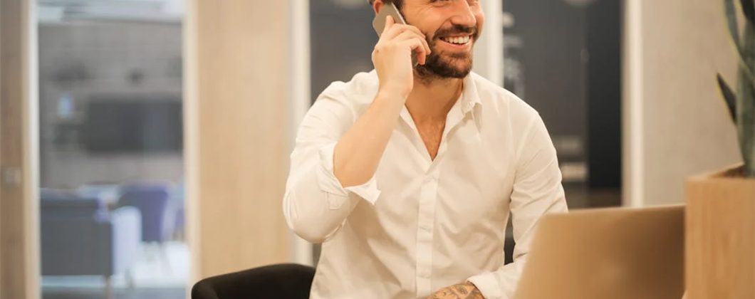 Smart man smiling while chatting on the phone.